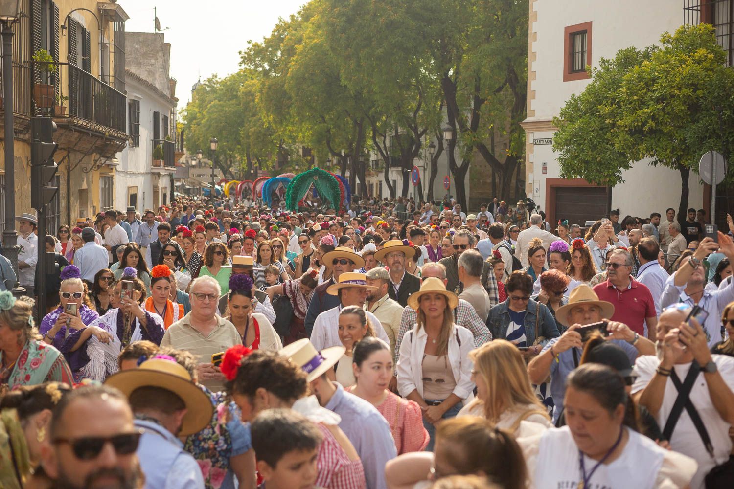 La calle Ancha llena de gente, con las carretas al fondo.