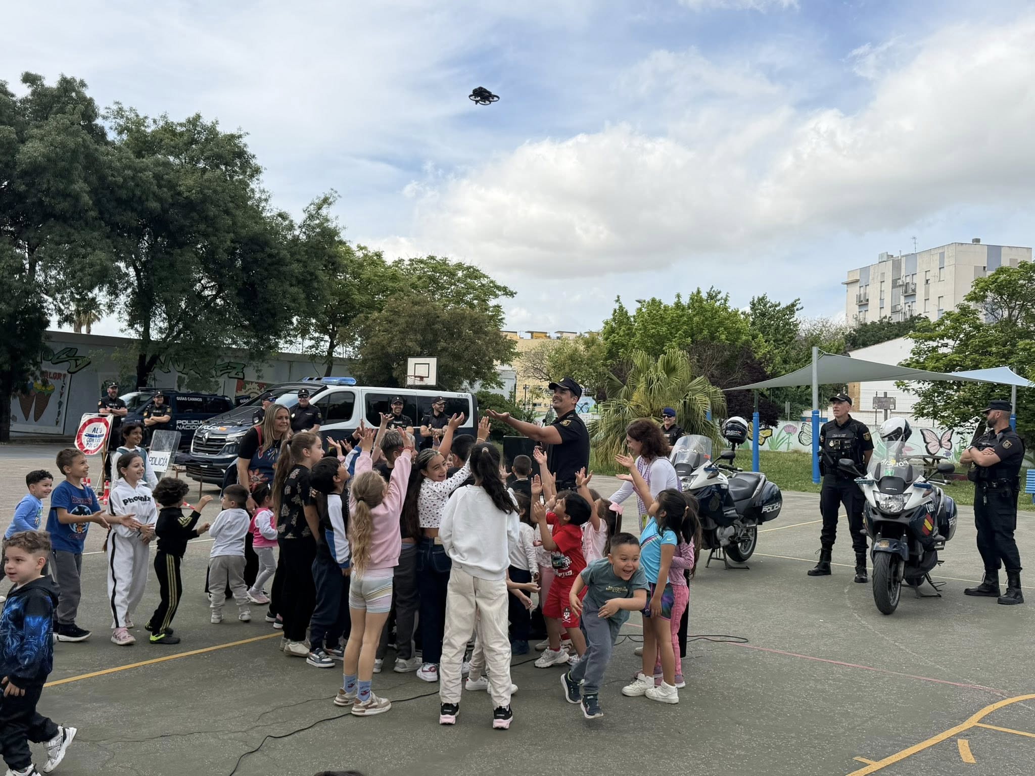 Convivencia con la Policía Nacional en el patio de un colegio de Jerez: los niños saludan al helicóptero y a los guías caninos