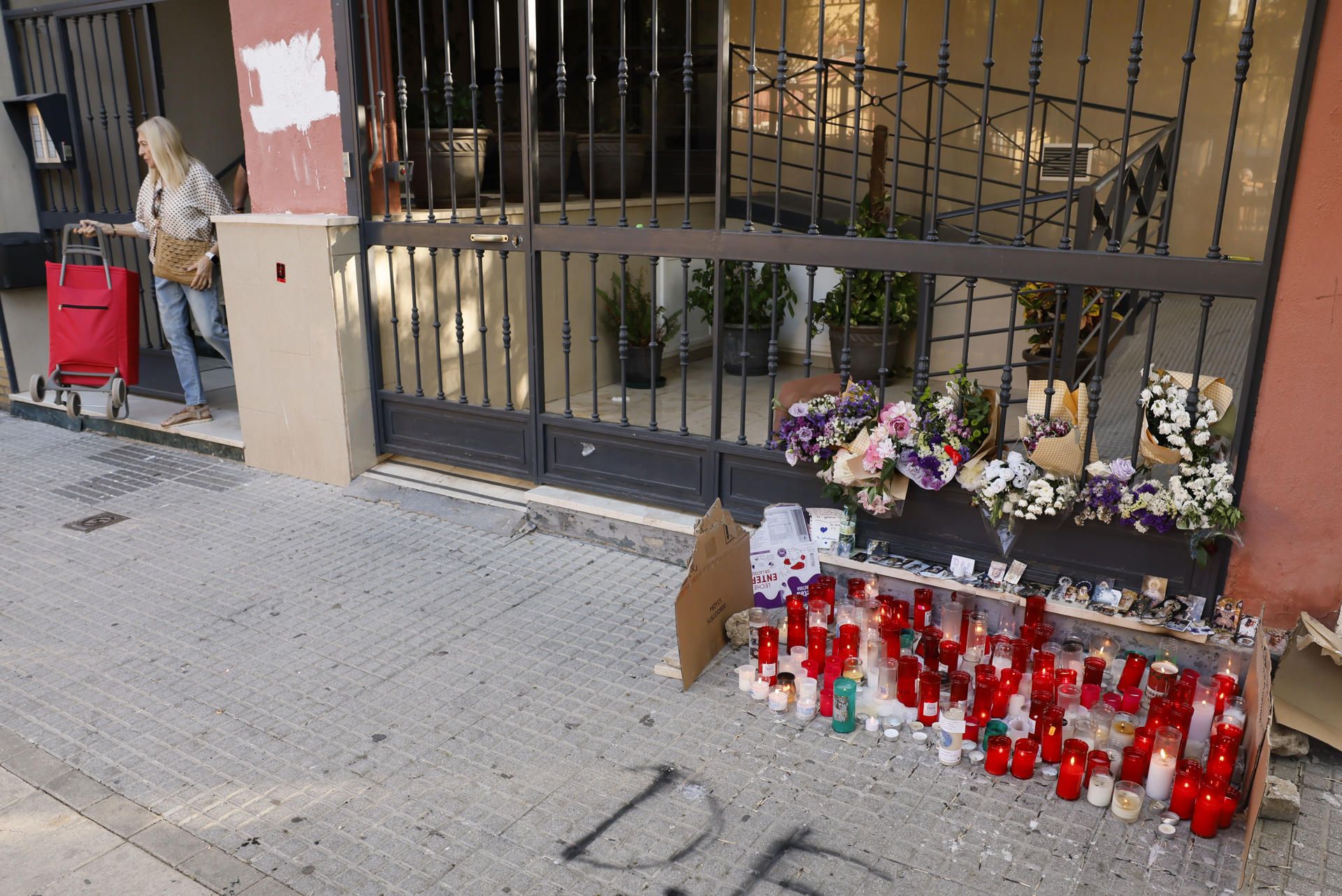 Un pequeño altar improvisado en el bloque donde vivía Sandra Peña. - JOSÉ MANUEL VIDAL / EFE