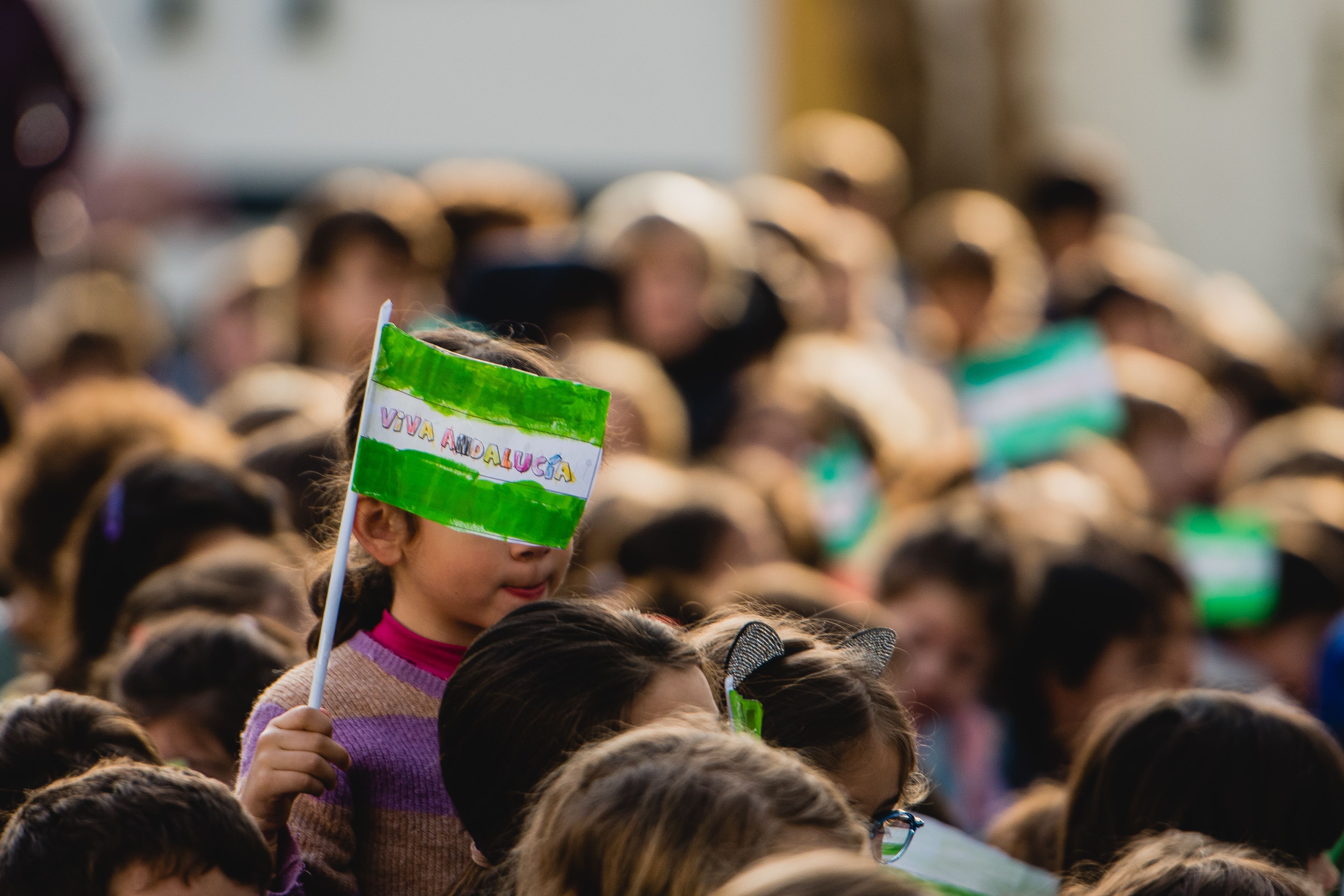Una pequeña porta una bandera de Andalucía. - MAURI BUHIGAS