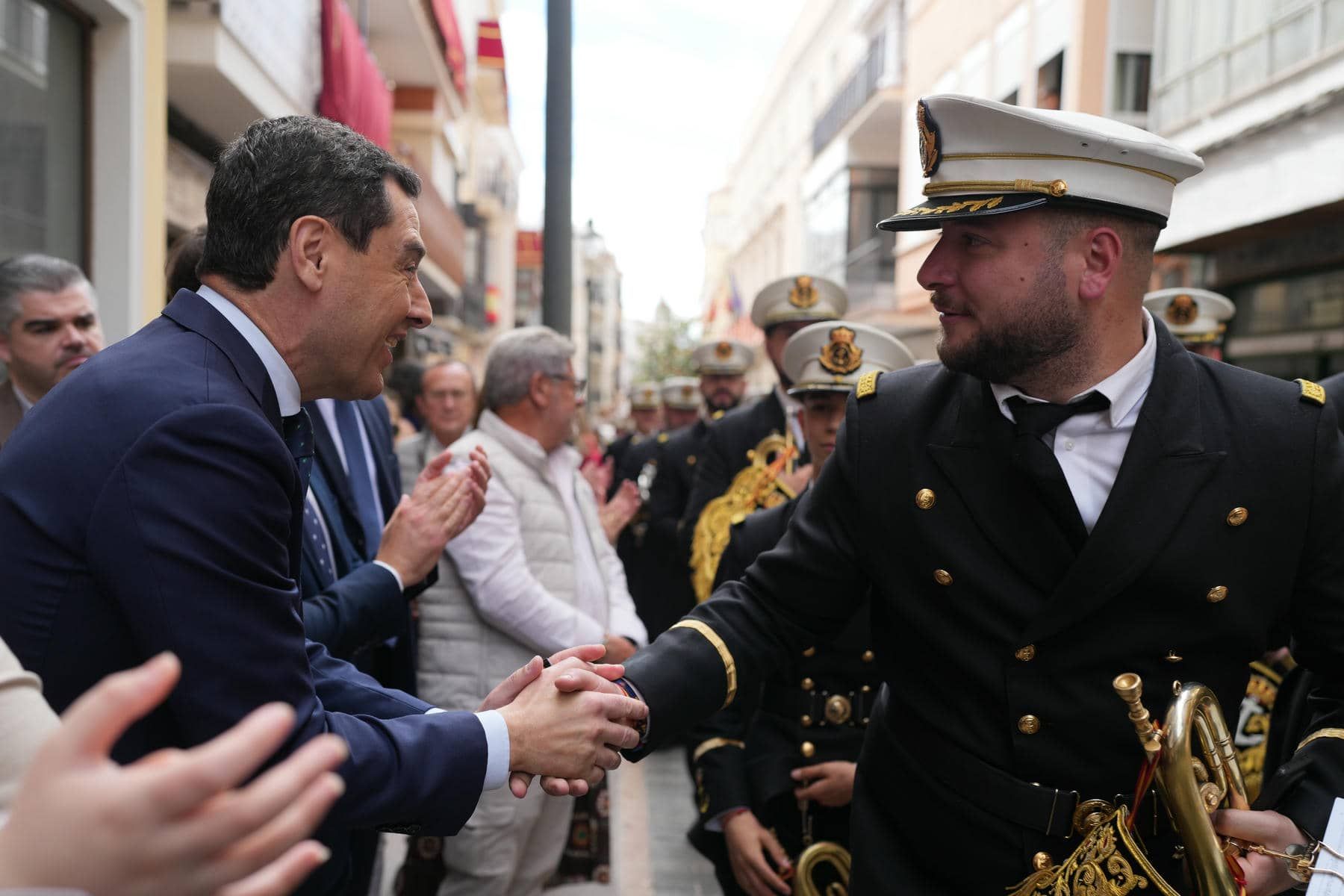 Un músico saluda a Juanma Moreno en la Semana Santa de Cabra - 