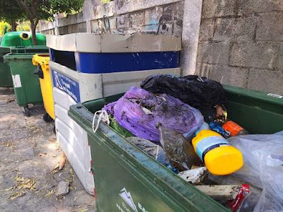 Contenedor de restos rebosando de residuos que deberían estar depositados en otros contenedores de al lado. - 