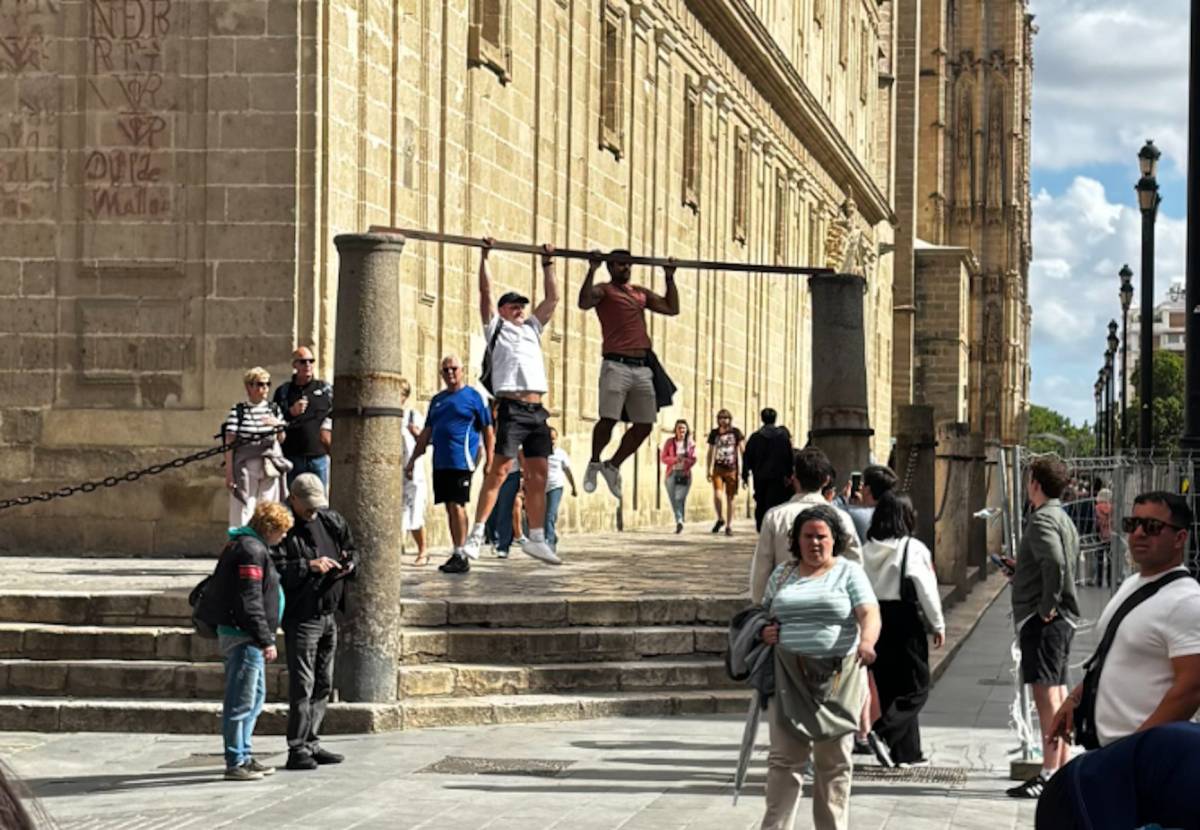 Insólita imagen junto a la Catedral de Sevilla: dos jóvenes usan dos columnas como barra para hacer dominadas