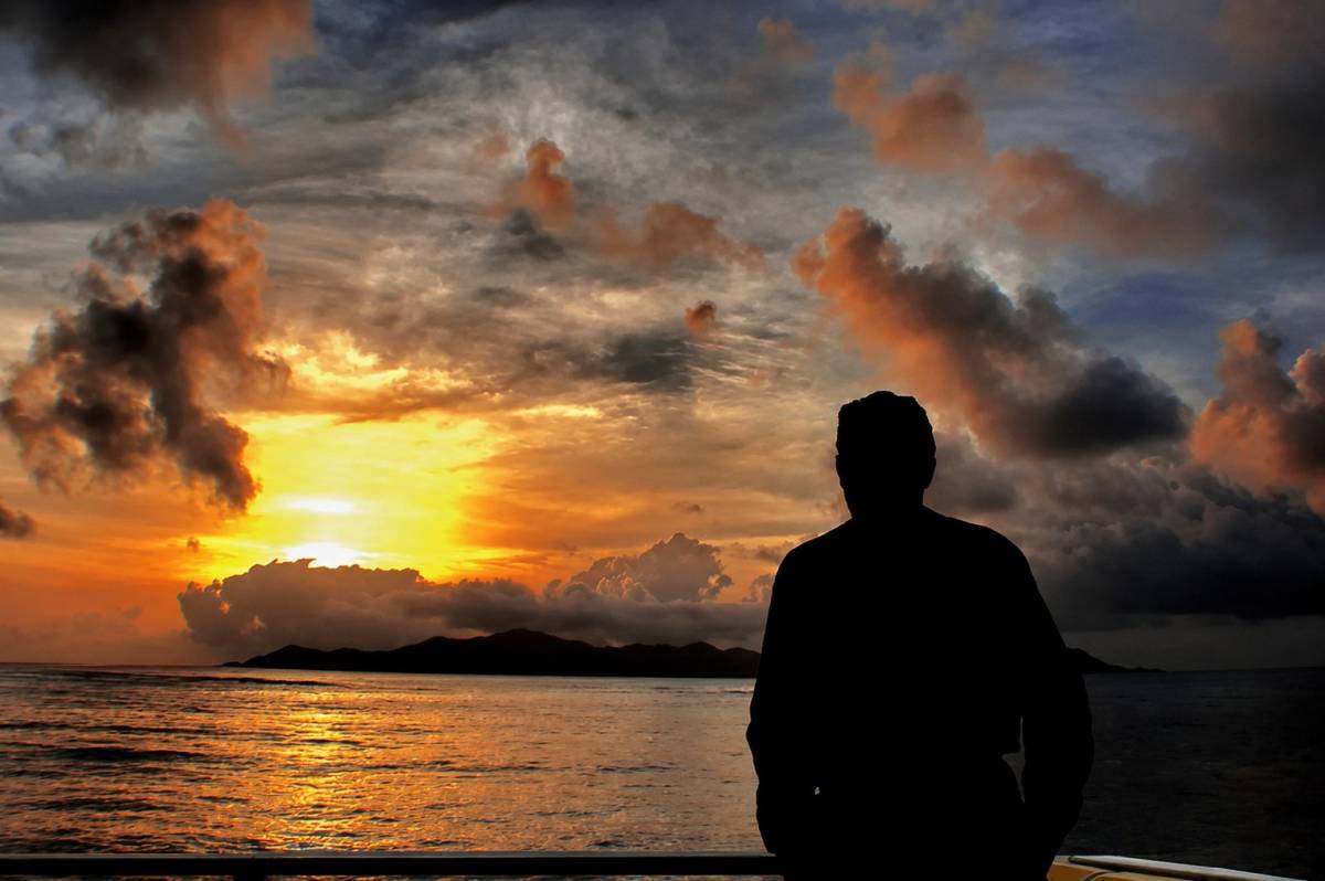 Un hombre observando una puesta de sol. - 