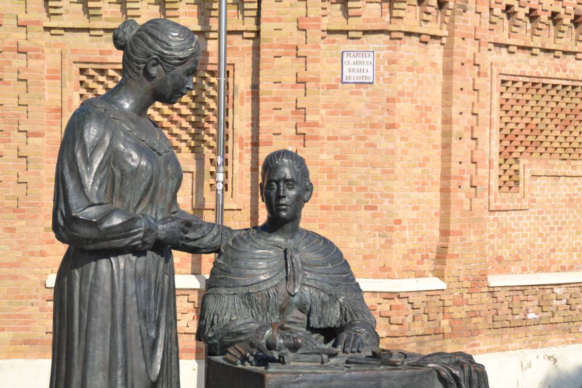 Monumento a las Cigarreras, detrás la fachada de la fábrica y placa nomenclátor. - Monumento a las Cigarreras, detrás la fachada de la fábrica y placa nomenclátor.