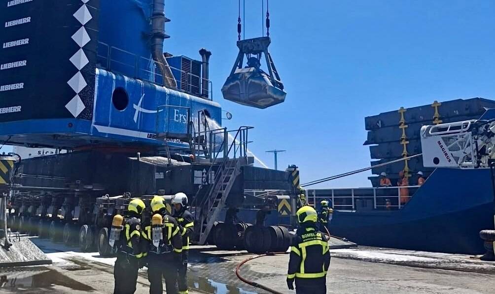 Efectivos de bomberos actuando en el lugar del incedio en el Muelle de la Cabezuela en el Puerto de Cádiz