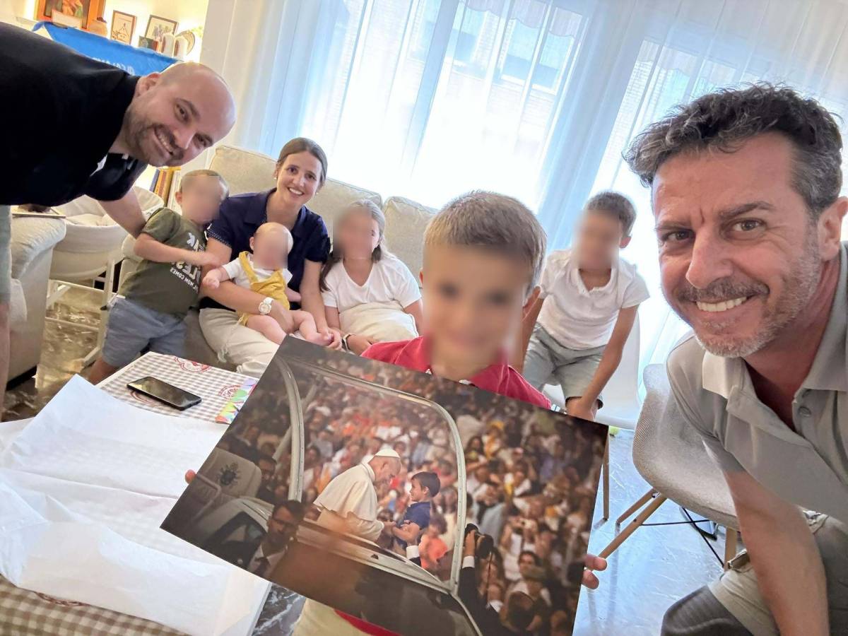 El fotógrafo Emilio Morenatti entrega la foto con el Papa a la familia del niño al que bendijo en Barcelona