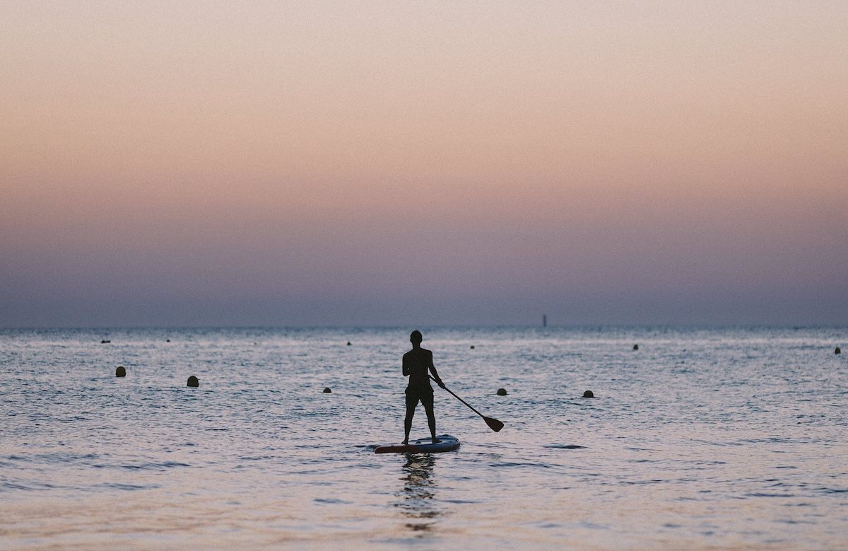 Una persona haciendo paddle surf en la playa. - ESTEBAN