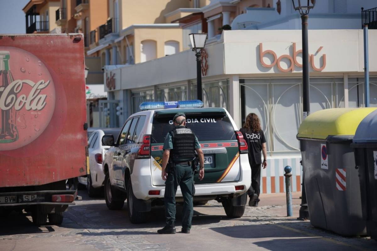 Los agentes, en la puerta del establecimiento del empresario.