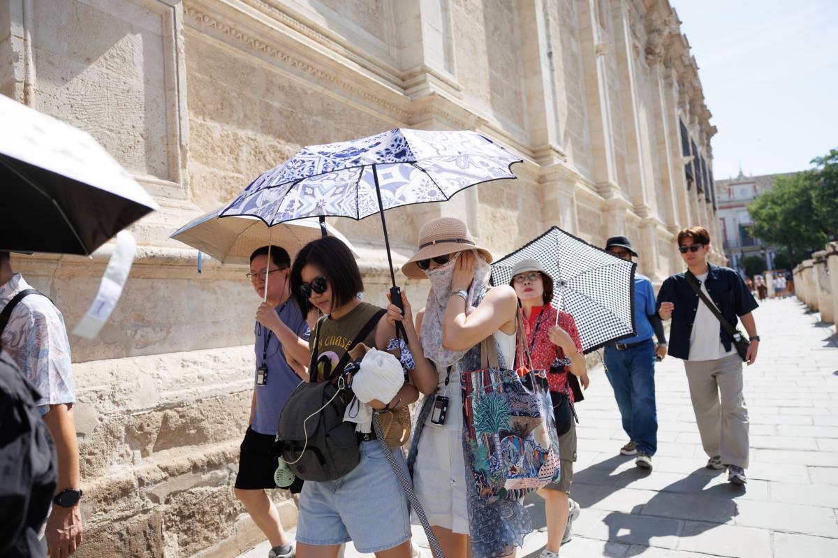 Turistas se protegen con paraguas de la de calor en Sevilla - Turistas se protegen con paraguas de la de calor en Sevilla