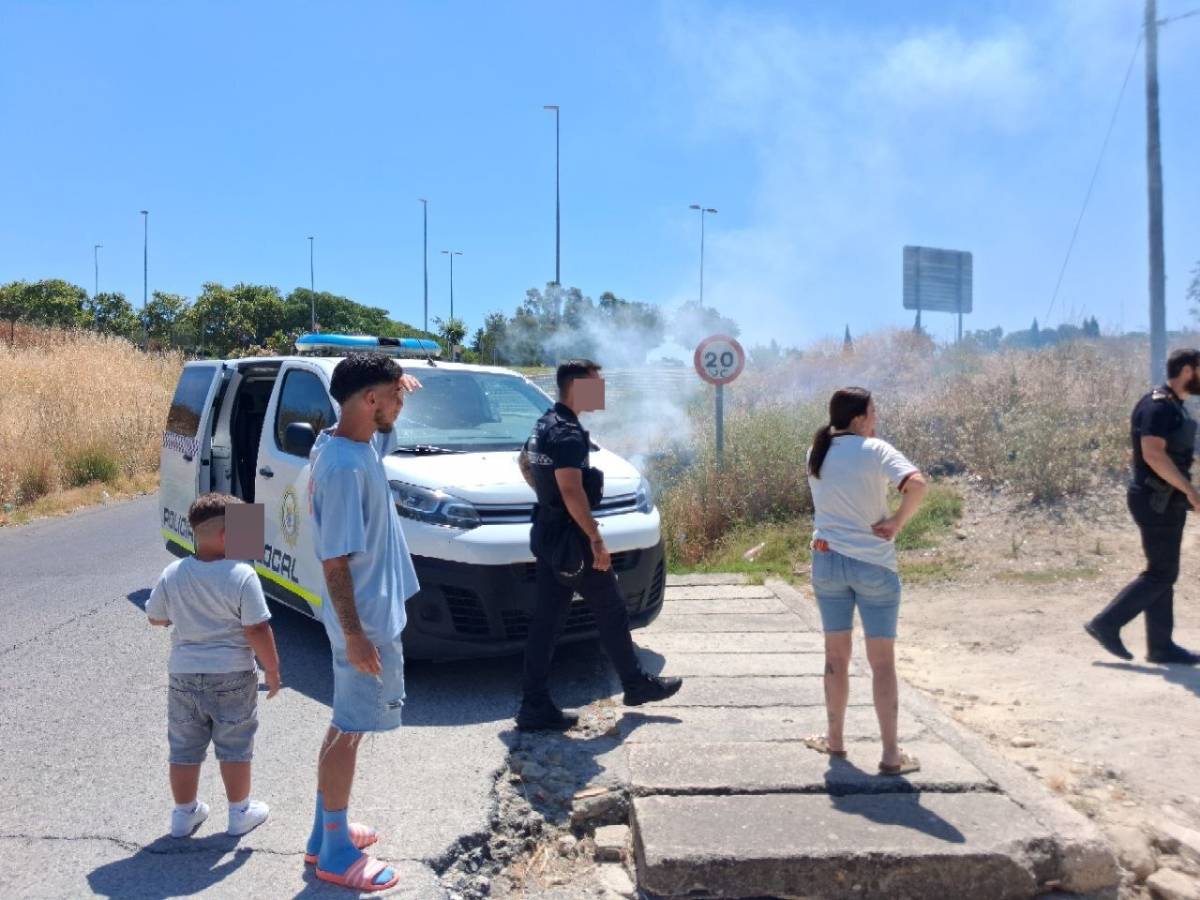 Vecinos y bomberos actúan ante un fuego junto a las viviendas situadas frente a la entrada de Área Sur y Luz Shopping