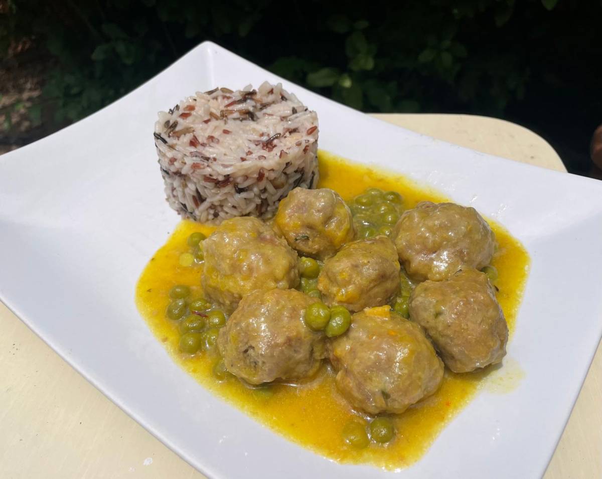 Un plato de albóndigas en salsa con guisantes. - 