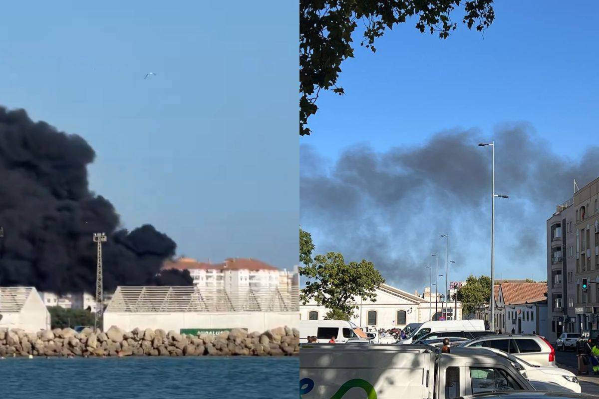 Gran columna de humo negro por un incendio en El Puerto en la desembocadura del Guadalete, en la zona de embarcaciones requisadas