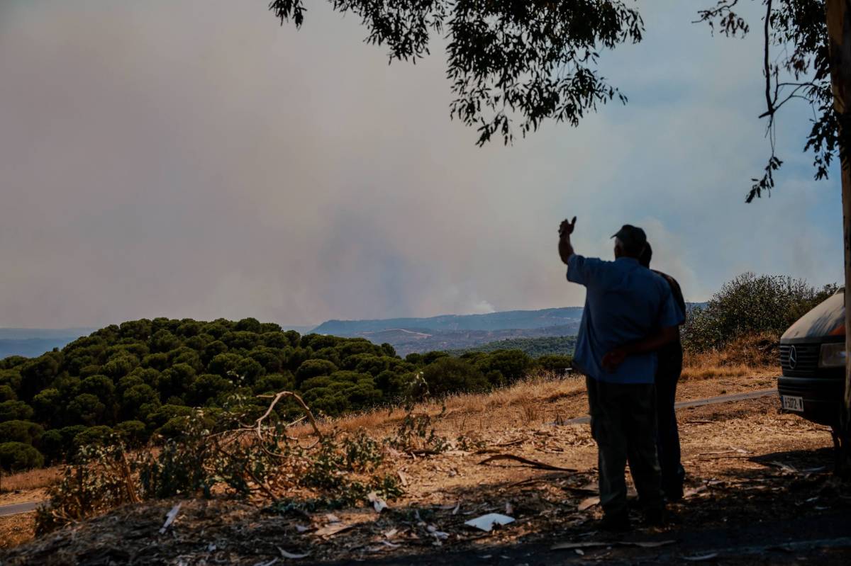 Vecinos de Nerva divisan el incendio en Niebla, este lunes.