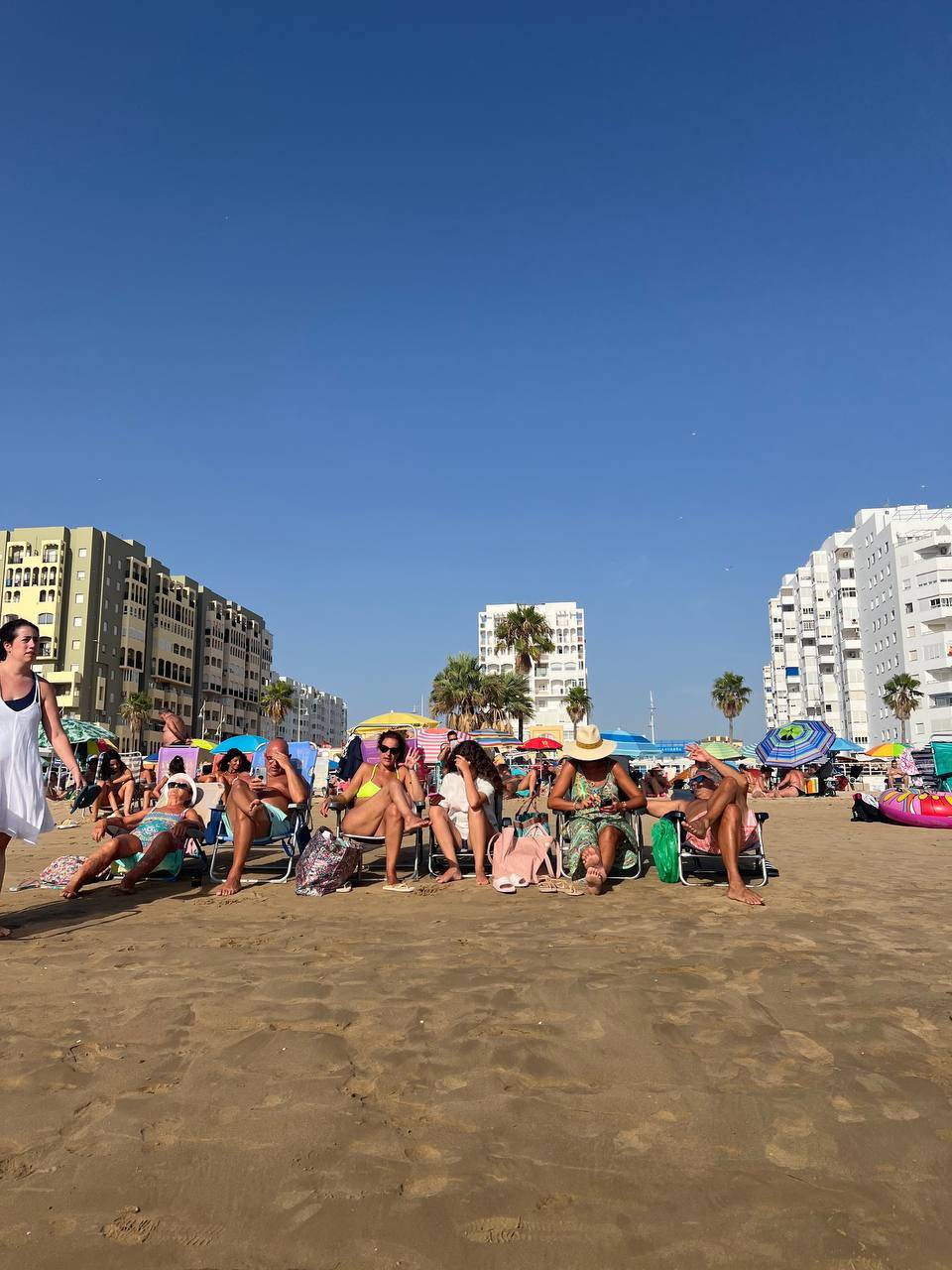 Un grupo en la arena esperando al eclipse llegar. 