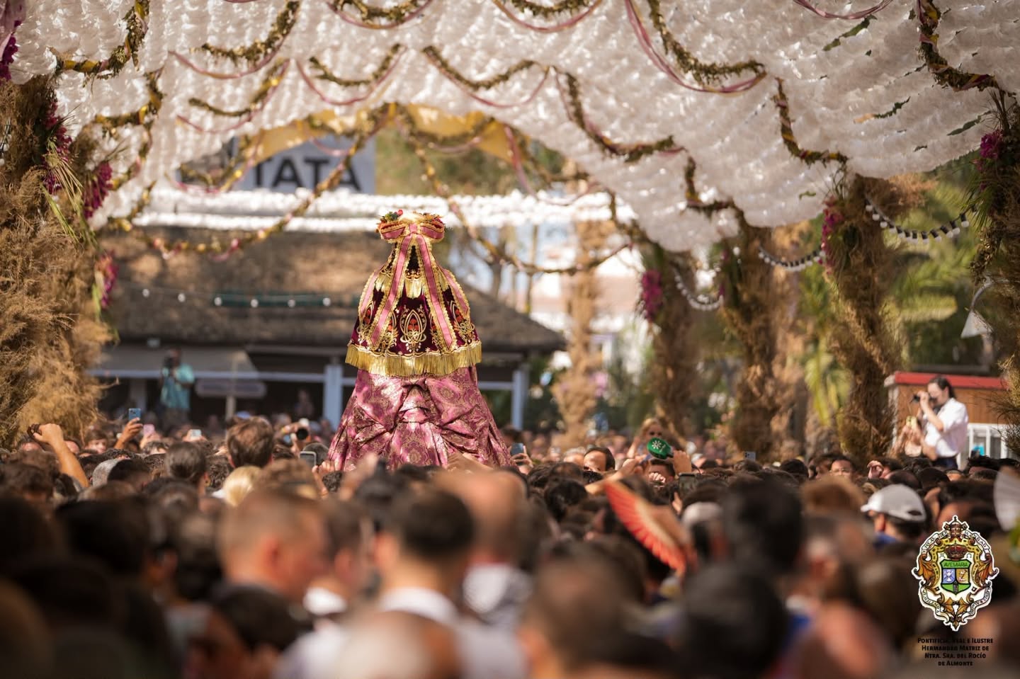 El tránsito de la Virgen bajo la cúpula de flores que marca el camino por la aldea. 