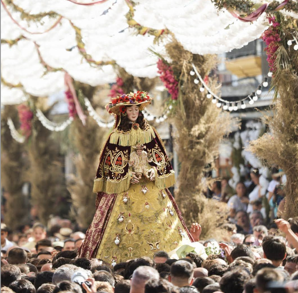 Bajo un toldo de flores blancas en el camino de la Virgen del Rocío por su aldea. 