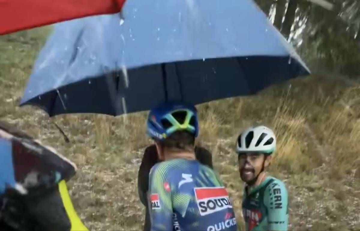 La granizada en La Vuelta deja una de las imágenes más surrealistas del año: varios ciclistas se refugian en el paraguas de un aficionado