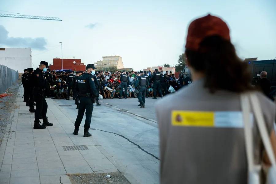 La Policía escolta a migrantes hasta un nuevo alojamiento en Ceuta.