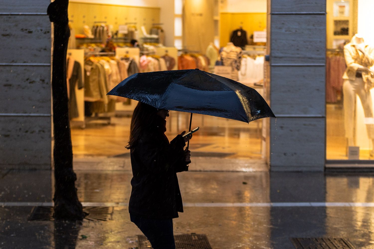 Una mujer se refugia de la lluvia. - MANU GARCÍA