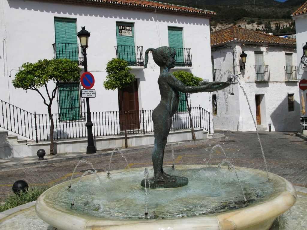 Una escultura de una niña en una fuente.   - 