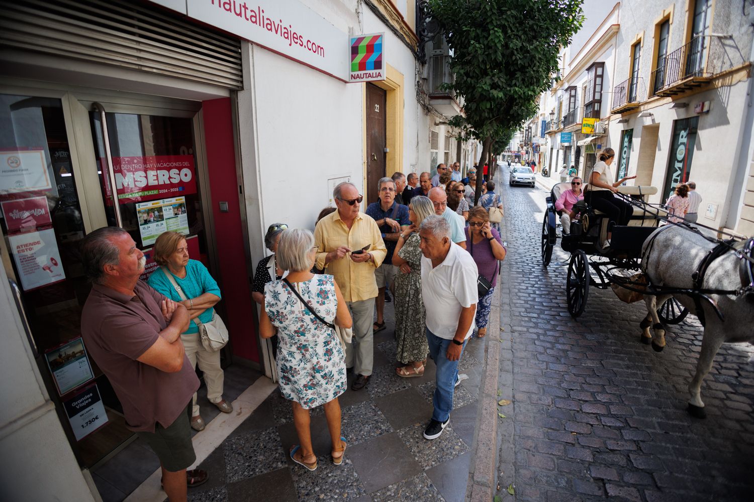 Programa de vacaciones del Imserso. Cola de personas aguardando su turno en la calle Honda, en una imagen de archivo.