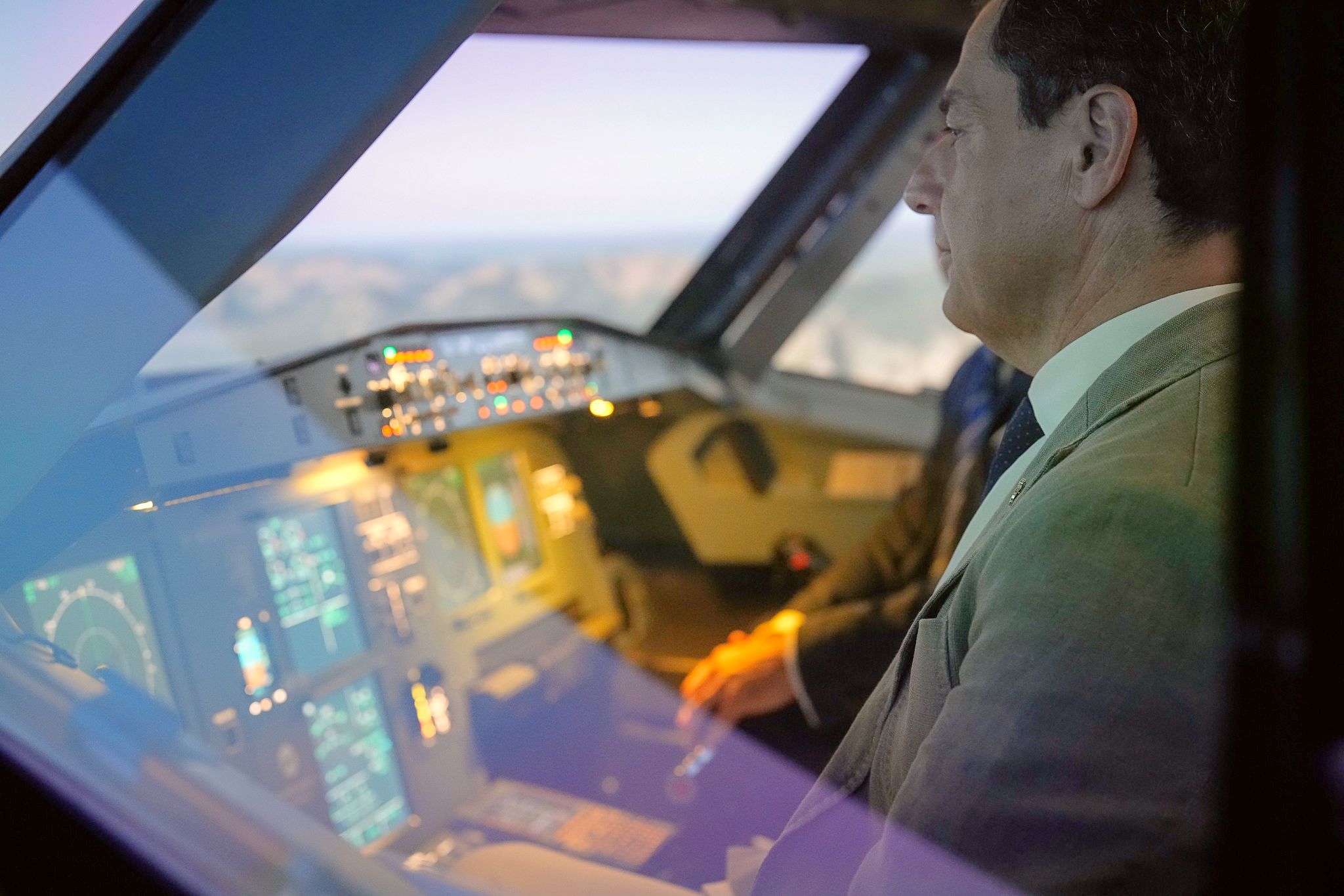 El presidente de la Junta, Juanma Moreno, en un simulador de vuelo durante una visita a una empresa andaluza del sector aeroespacial. - 