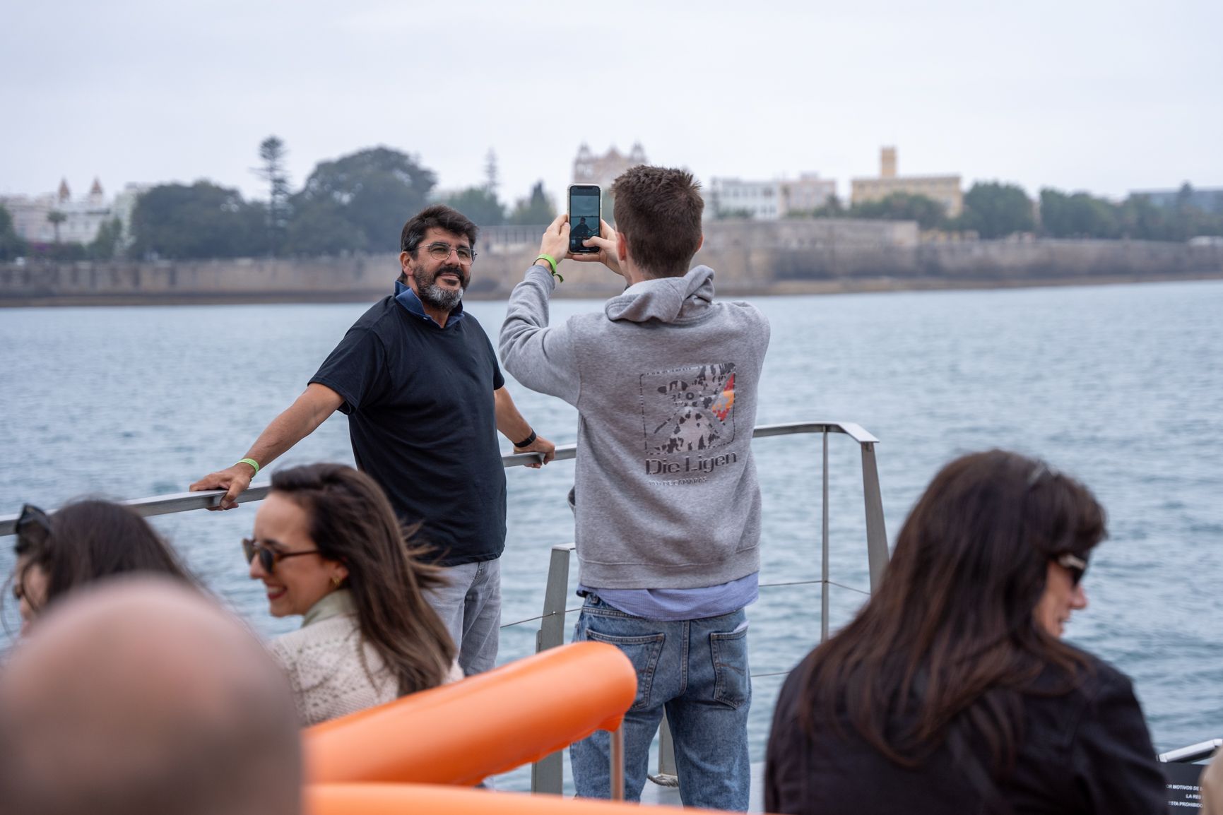 Visitantes se fotografían en Cádiz a bordo de un catamarán turístico.