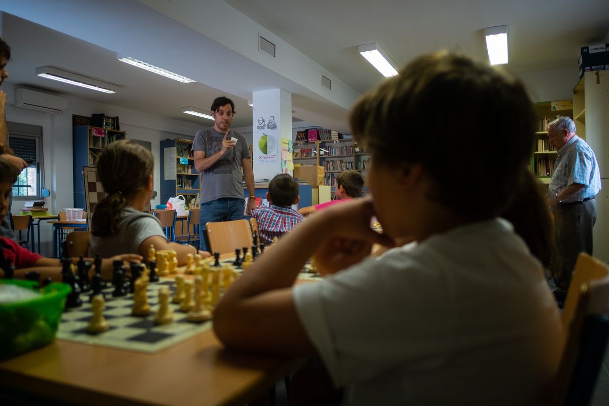 Un profesor enseña a los niños y niñas cómo hacer un 'jaque mate' con dos torres. - MANU GARCÍA