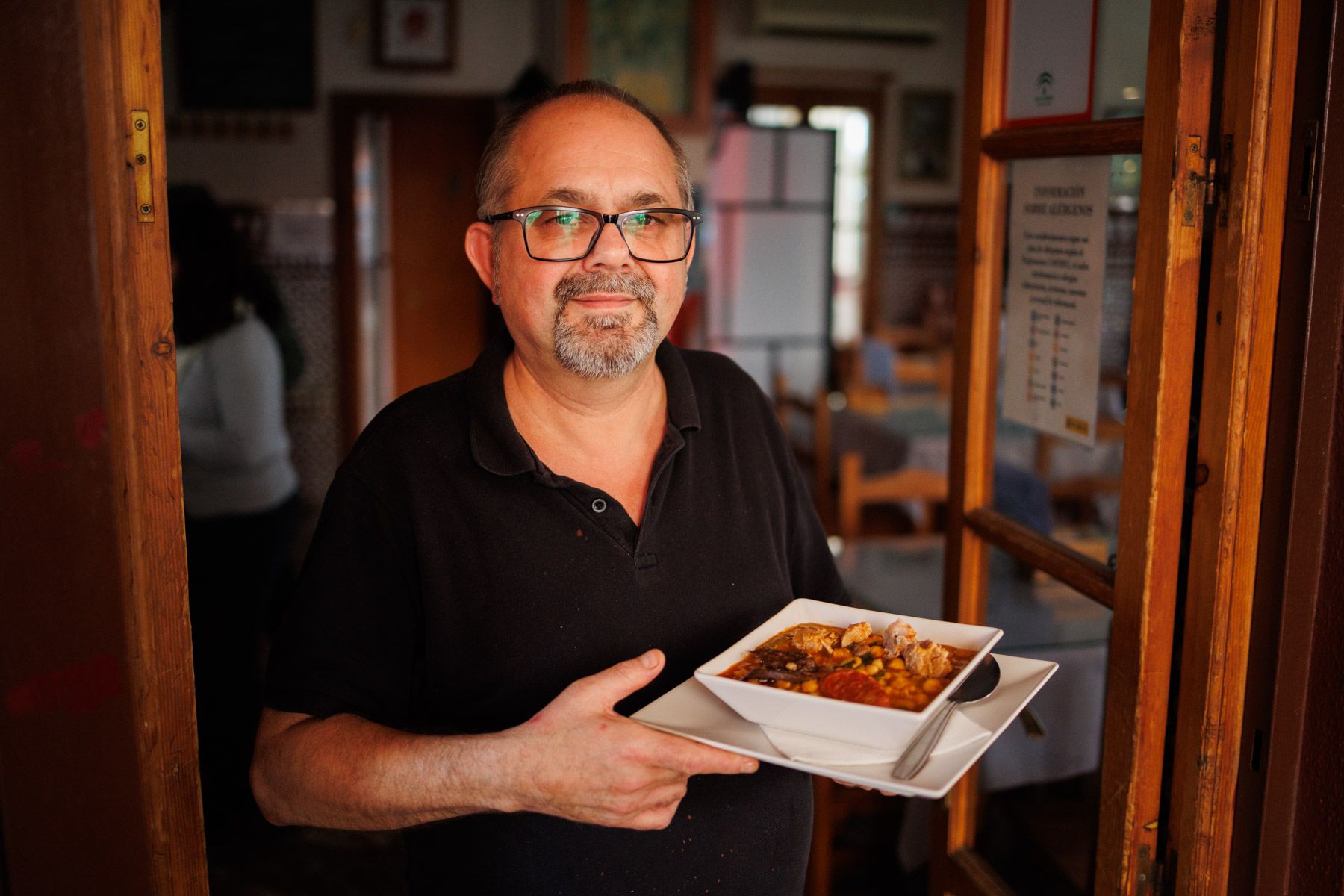 Fermín, propietario, del bar, con un plato de berza jerezana. - MANU GARCÍA