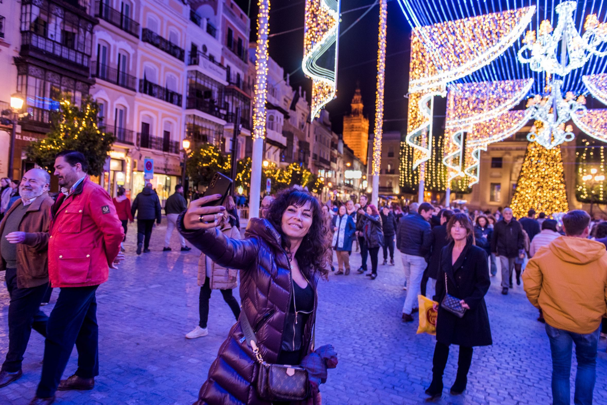Una personas se hace un 'selfie' con el alumbrado navideño de Sevilla. - MAURI BUHIGAS