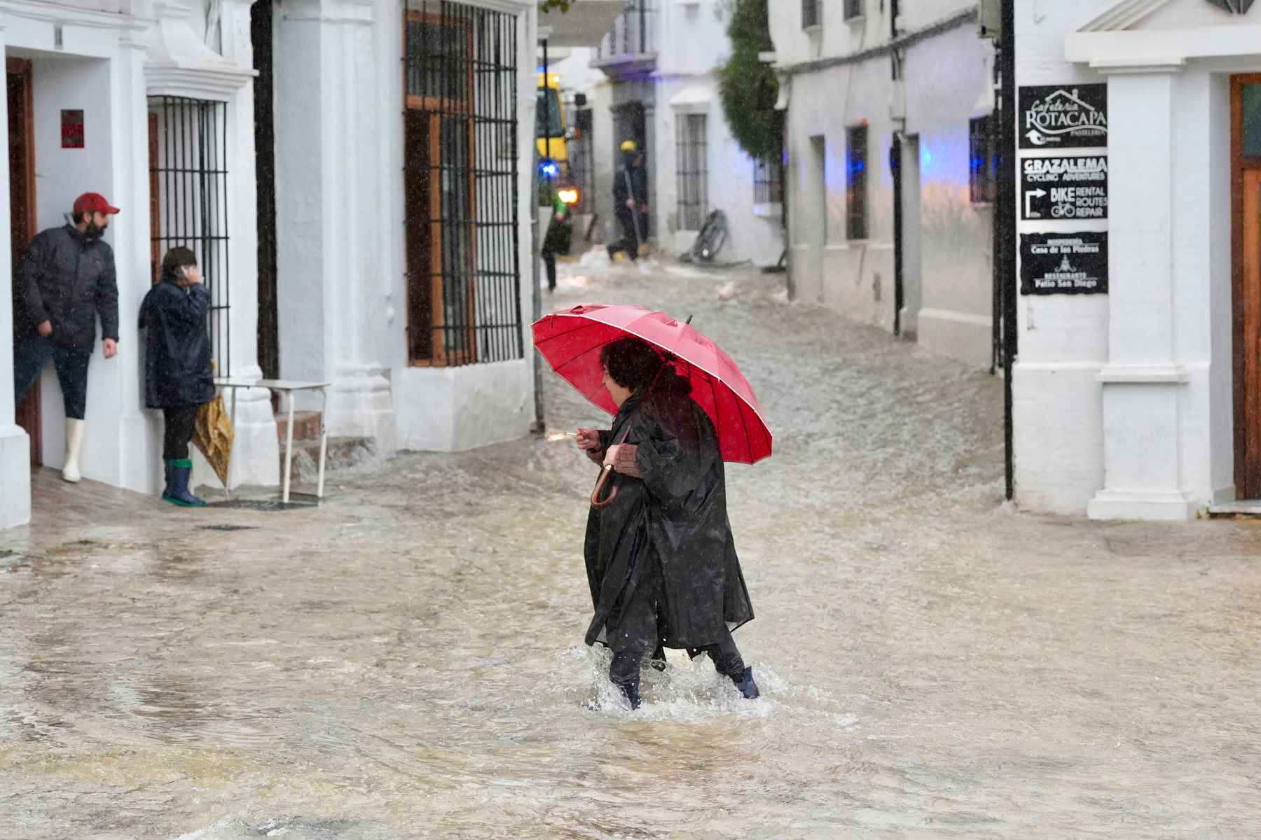 Una vecina de Grazalema camina por una calle inundada debido a las intensas lluvias - 