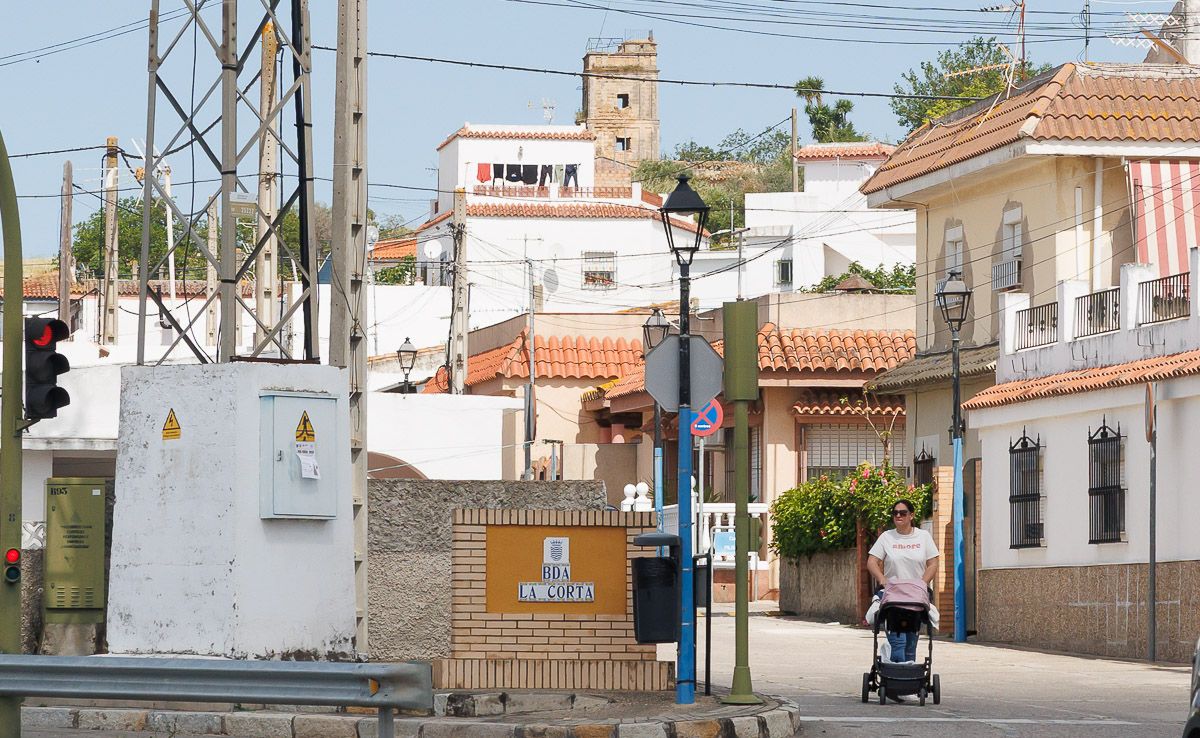 Un vecina pasea a su bebé por la calle principal de La Corta, barriada rural de Jerez.  - JUAN CARLOS TORO