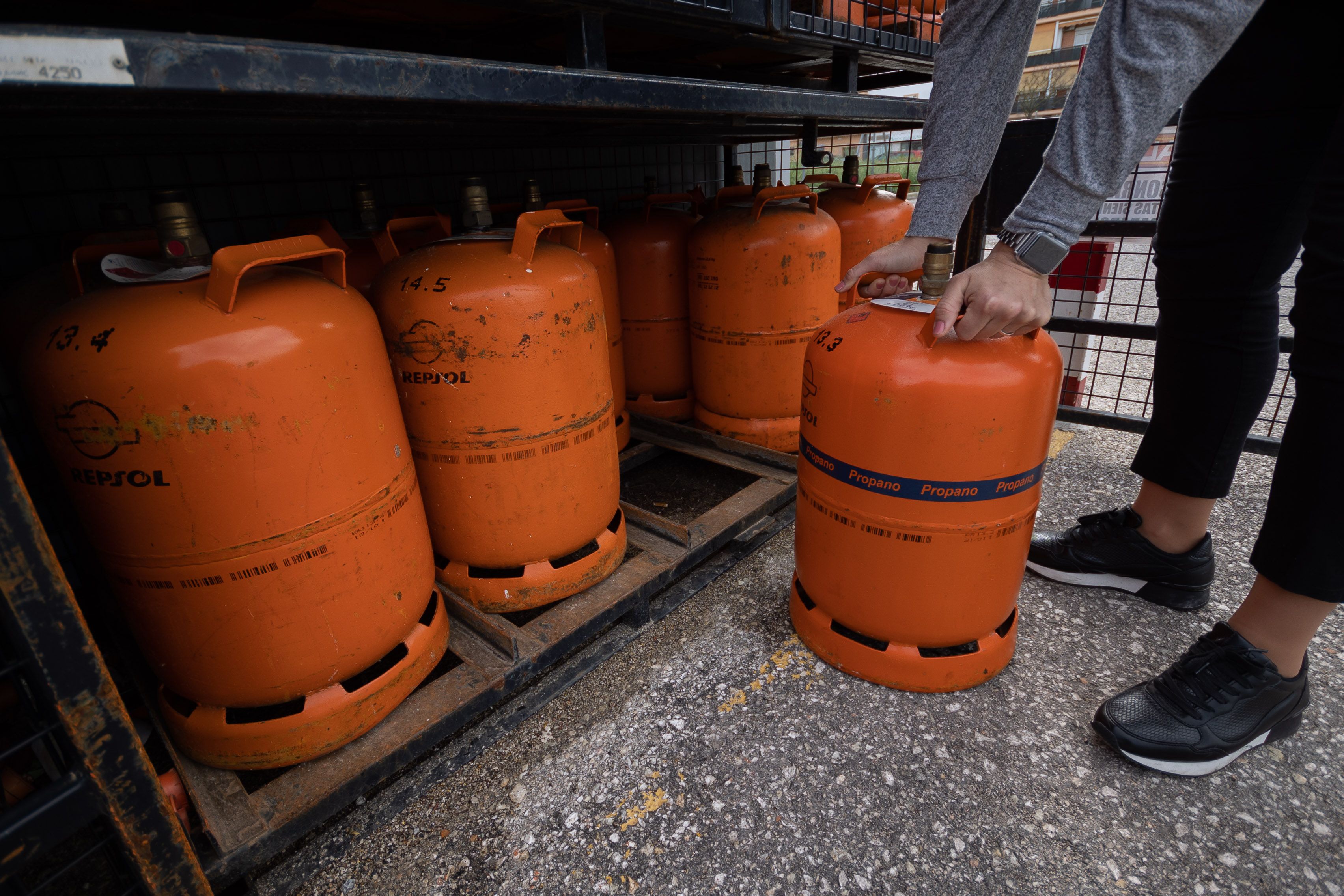 Una persona compra una bombona de butano en una gasolinera.