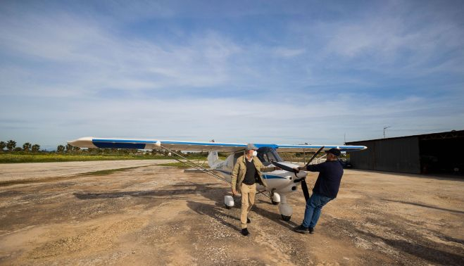 Los aficionados preparan el ultraligero en la pista.