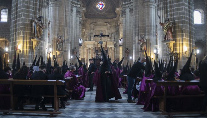 Hermanos de La Viga sentados en la bancada de la Catedral esperando la decisión de salir o no.   CANDELA NUÑEZ