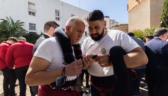 Costaleros de La Salvación mirando los trabajos que les tocaba bajo el paso.    MANU GARCÍA