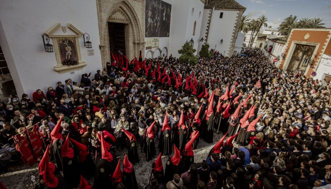 El río de nazarenos rojo y negros entre la multitud que llenó la plaza de San Mateo.    ESTEBAN