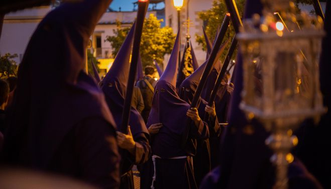 Nazarenos del Loreto con la cera alzada.  MANU GARCÍA