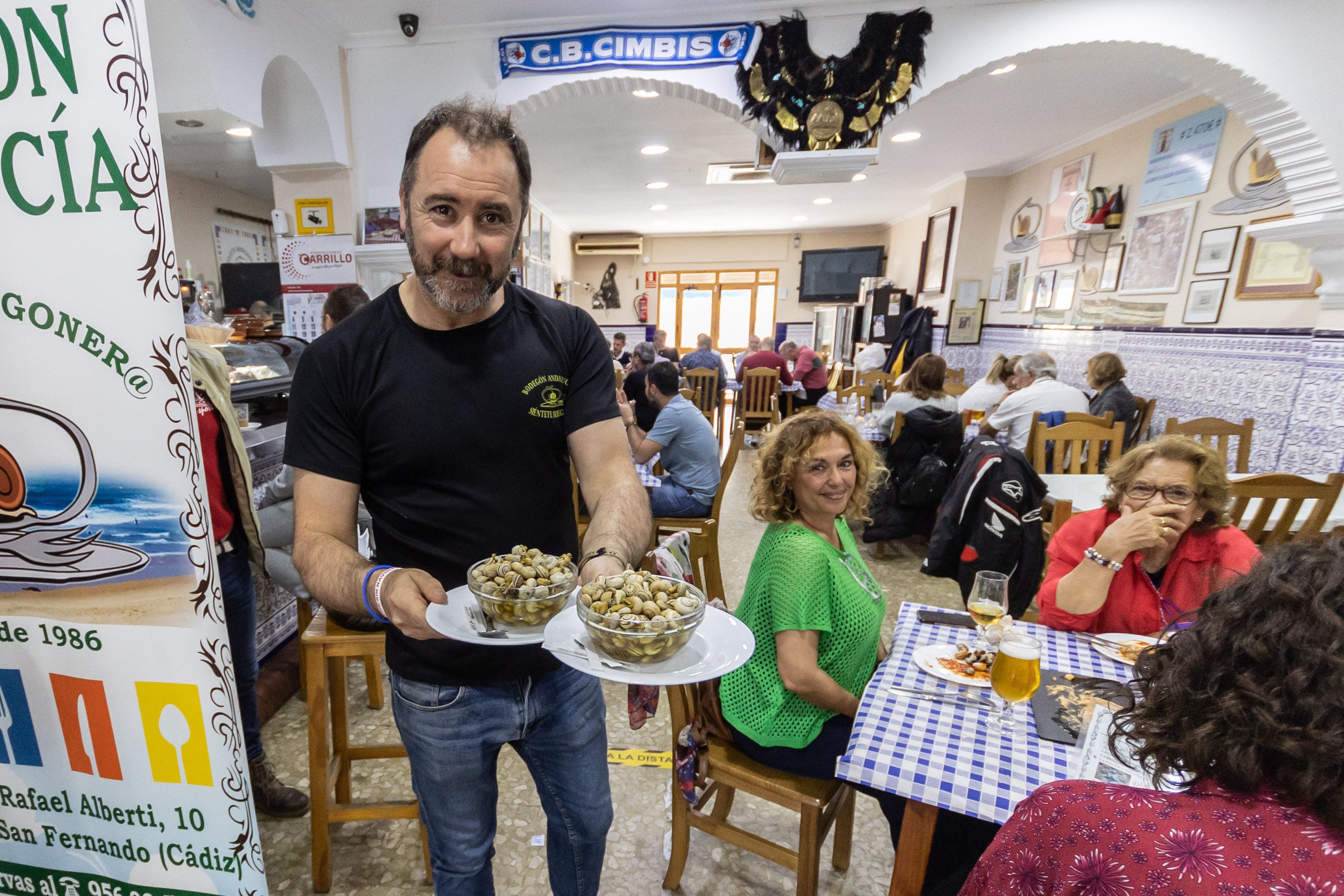 Alfonso lleva unas tapas de caracoles a una de las mesas.