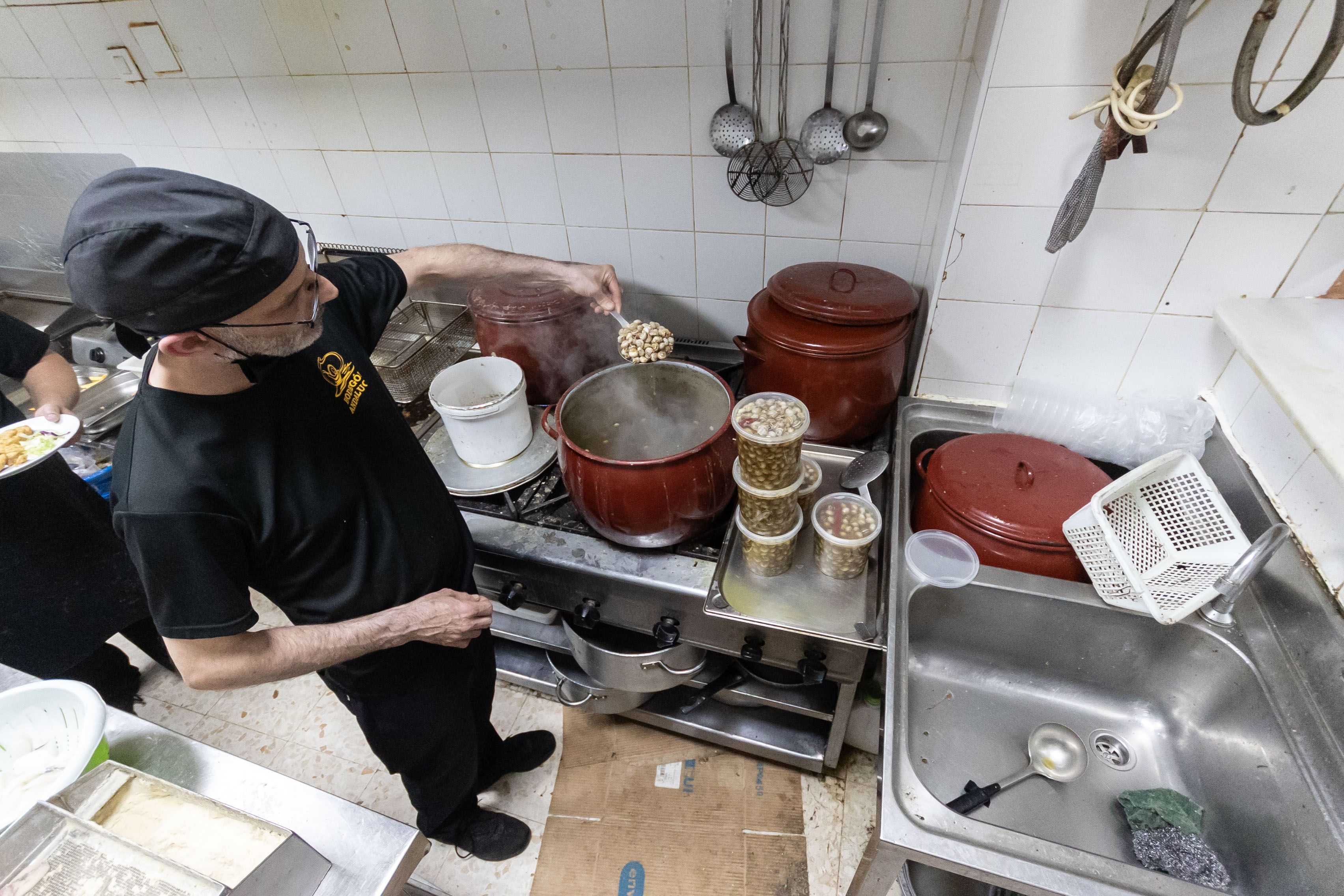 Un cocinero controla la olla de caracoles.