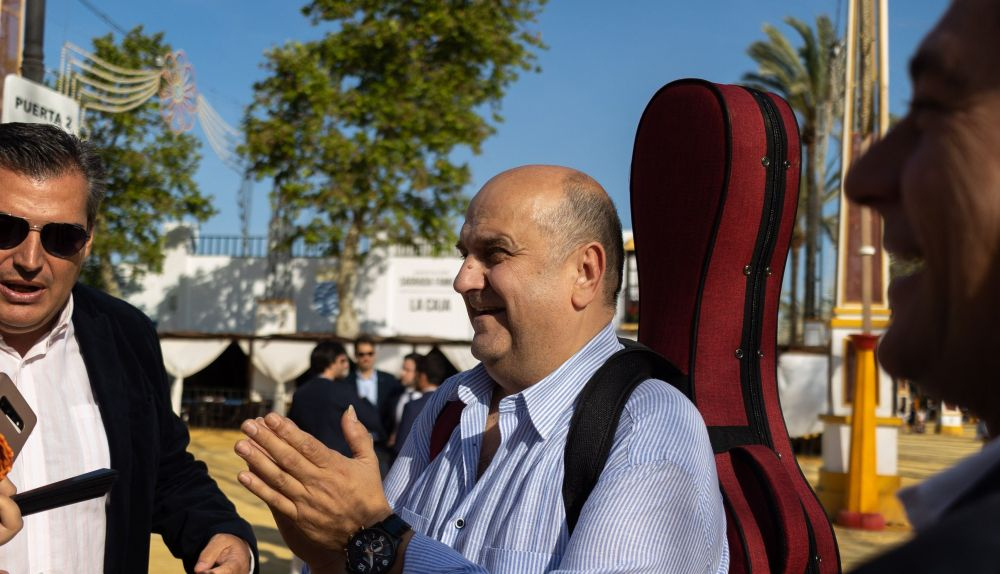 "Trabajar en la Feria no siempre está bien pagado". Lupi y su grupo en el Real con su guitarra de camino a una actuación.