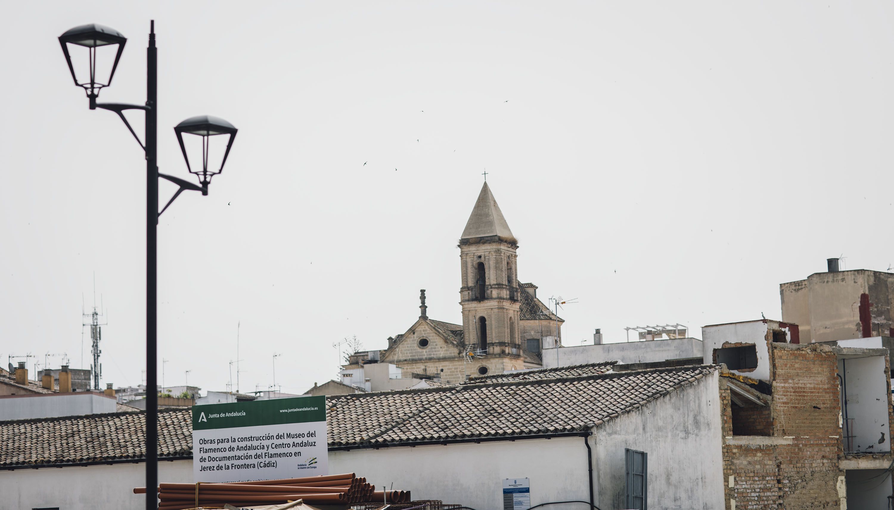 Cartel de la obra del Museo del Flamenco, con la torre del Carmen al fondo.    ESTEBAN