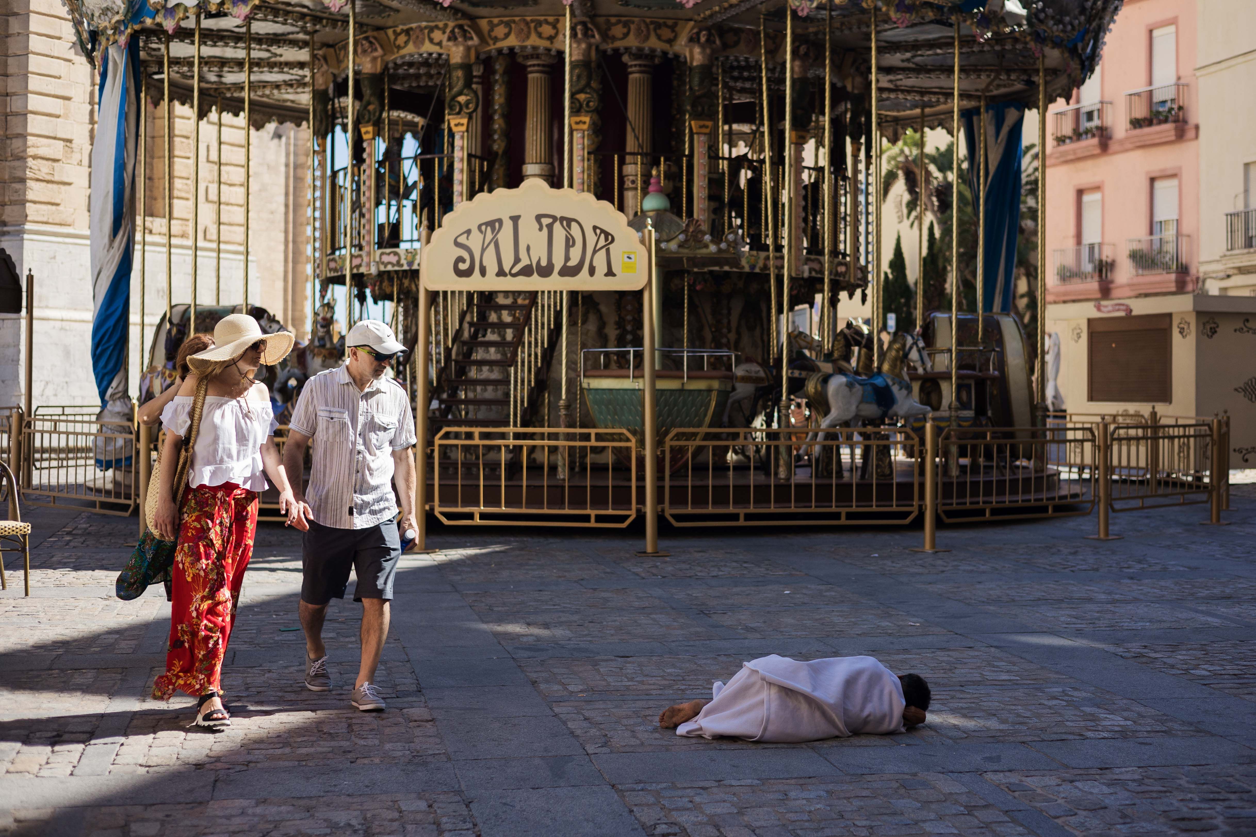 Imagen de archivo con una persona sin hogar tumbada en la plaza de la Catedral en Cádiz.