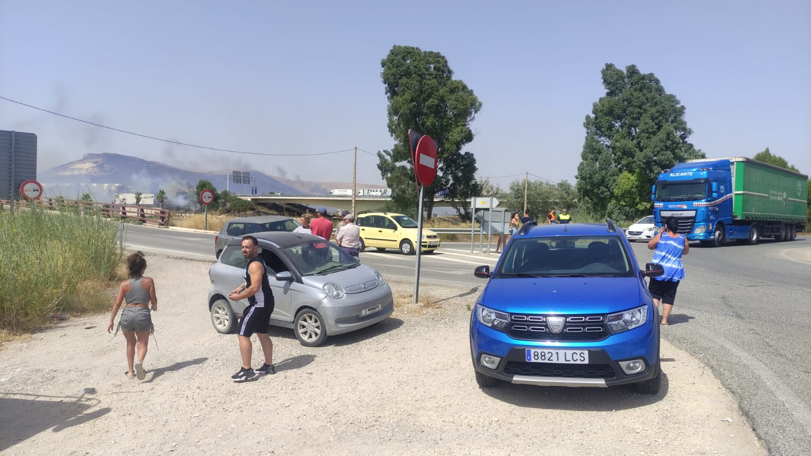 Conductores varados ante el avance de las llamas, con el cerro de Lomopardo, negro por el fuego, al fondo, este miércoles en Jerez. Conductores varados ante el avance de las llamas, con el cerro de Lomopardo, negro por el fuego, al fondo, este miércoles en Jerez.