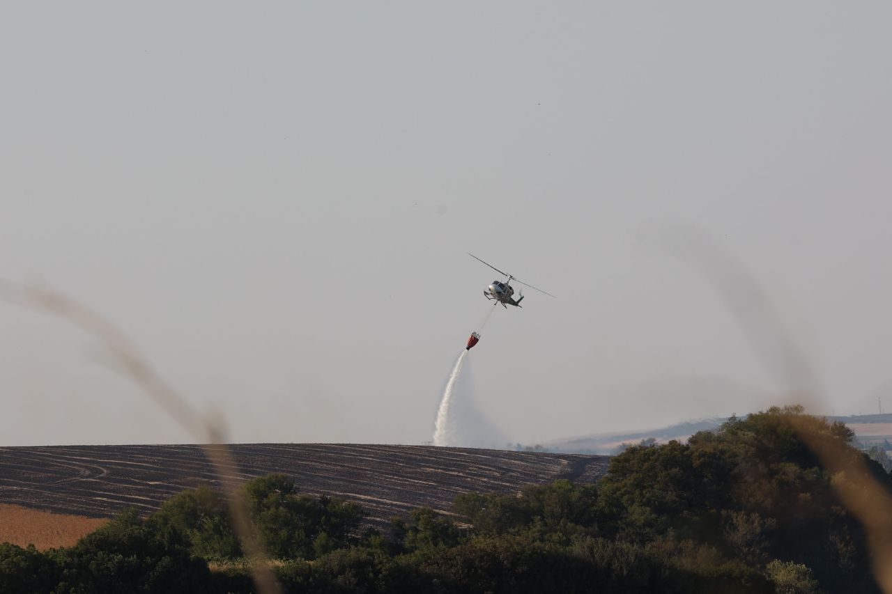 Un helicóptero de Infoca vierte agua sobre el nuevo foco en el incendio de Jerez, esta tarde de jueves. Un helicóptero de Infoca vierte agua sobre el nuevo foco en el incendio de Jerez, esta tarde de jueves.