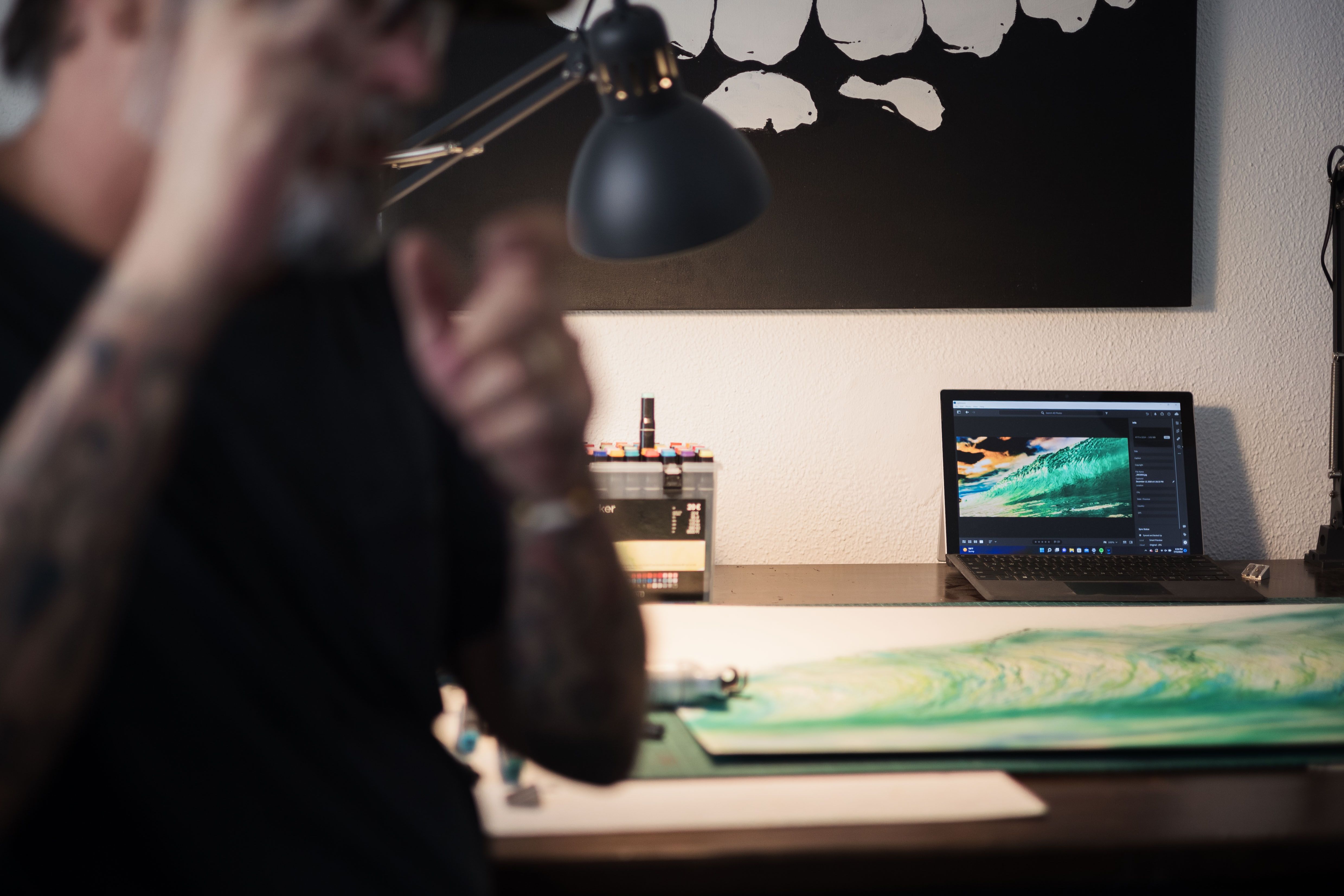 Detalle del portátil con una de las fotografías que plasma en el papel.