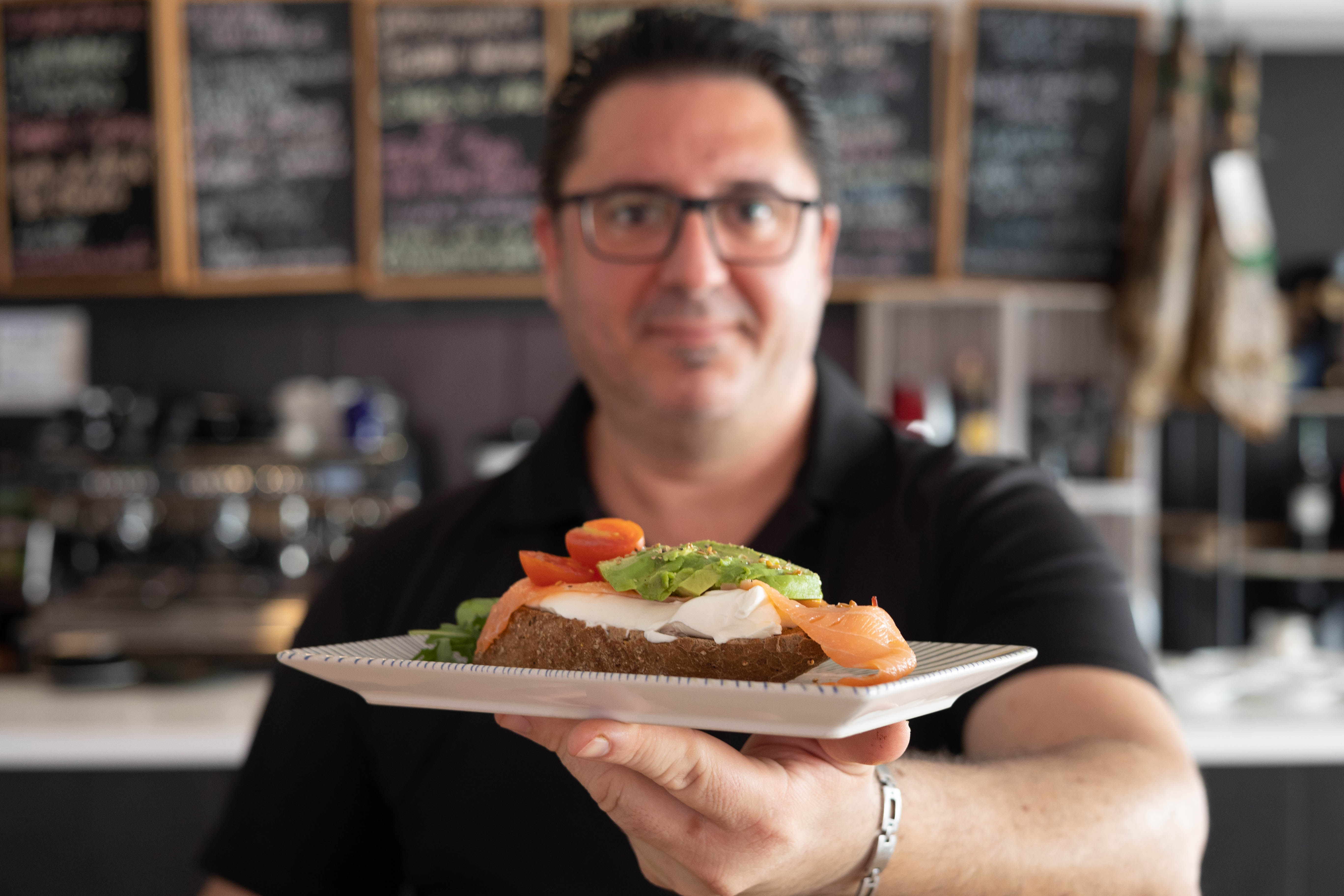 El hostelero con una de sus tostadas en el interior del local.