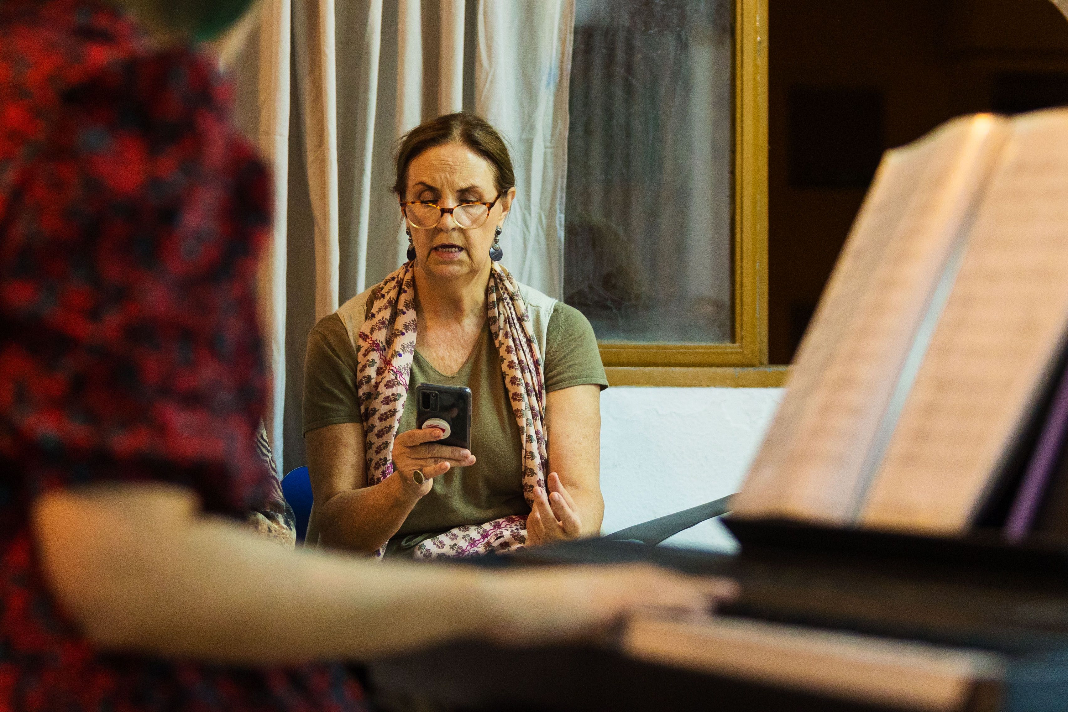 La directora, al piano, dando indicaciones a una coralista.    MANU GARCÍA