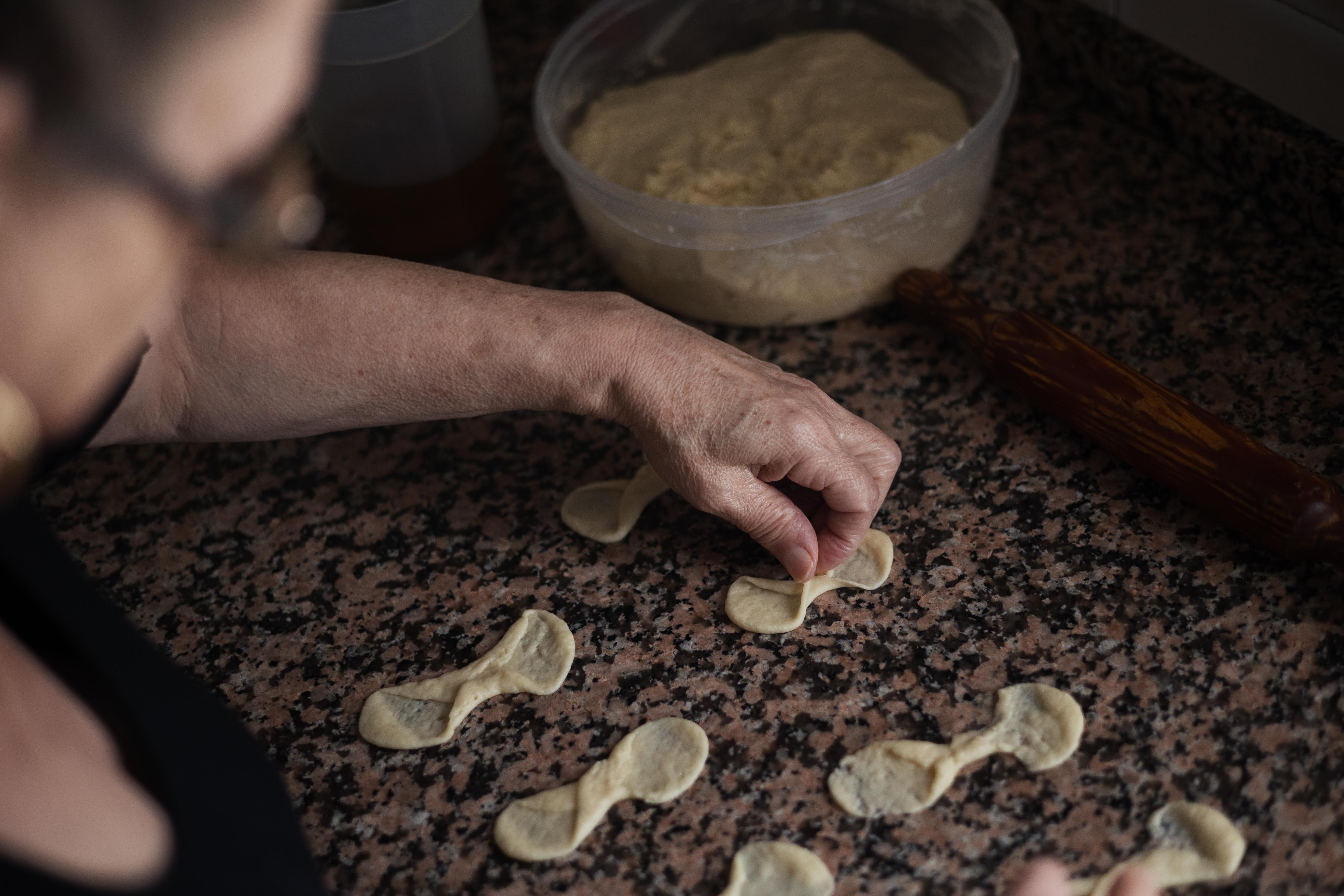 Juana da forma a la masa en su cocina.
